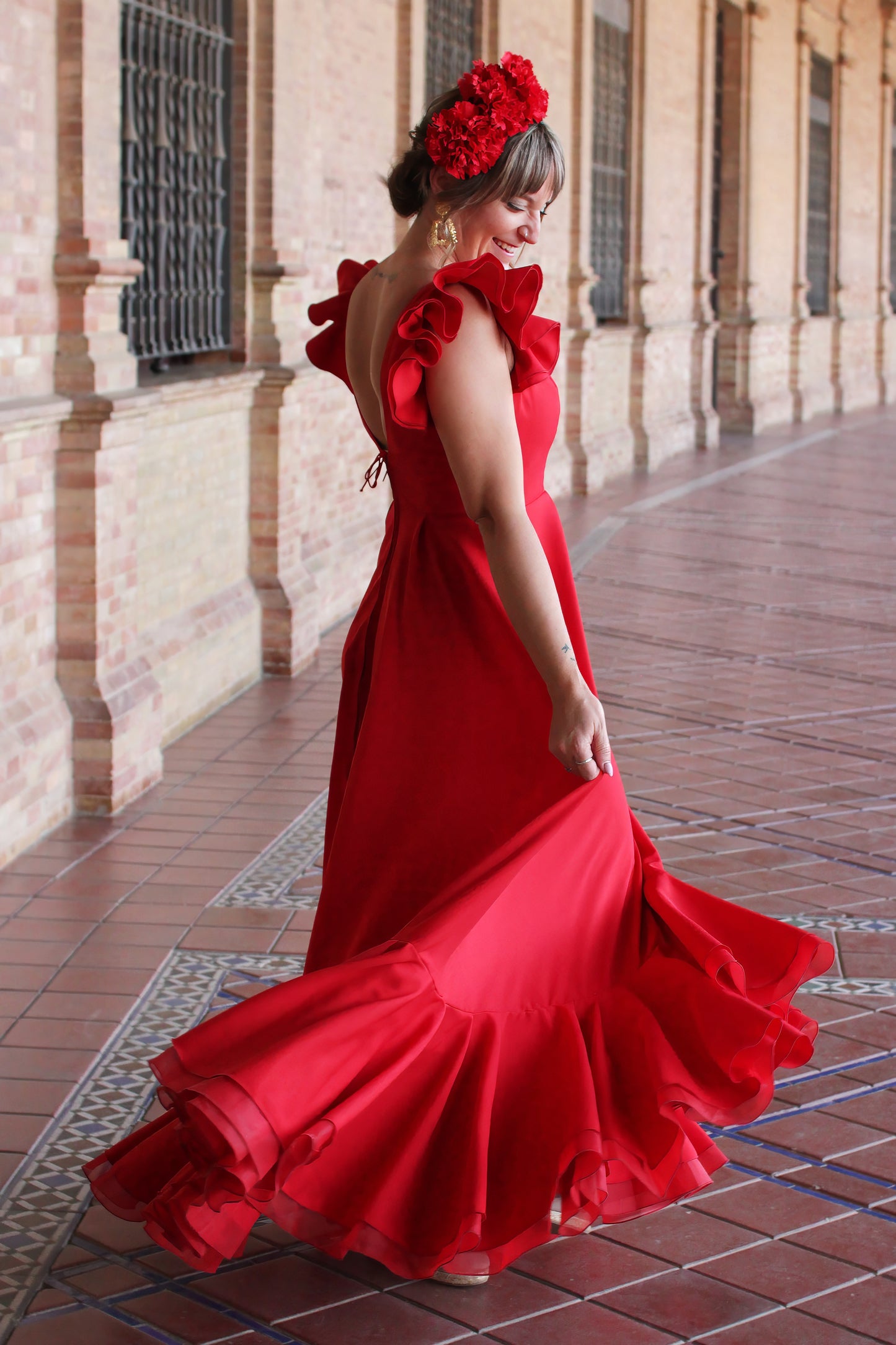La Bata Flamenca Roja Girasol, combinada con el Ramillete Rojo Pasión y los Pendientes Dorados Carmona, es el look ideal para destacar en cualquier romeria. Una elección cómoda, fresca y llena de estilo flamenco.