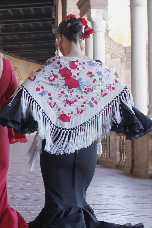 El mantón gris Noa con flores rojas es el complemento perfecto para un look flamenco sobrio, elegante y lleno de distinción.