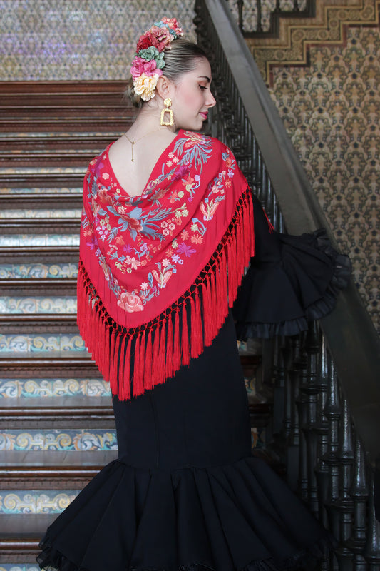 El mantón rojo Noa con flores naranjas es la pieza perfecta para dar un toque de energía y pasión a tu look flamenco.