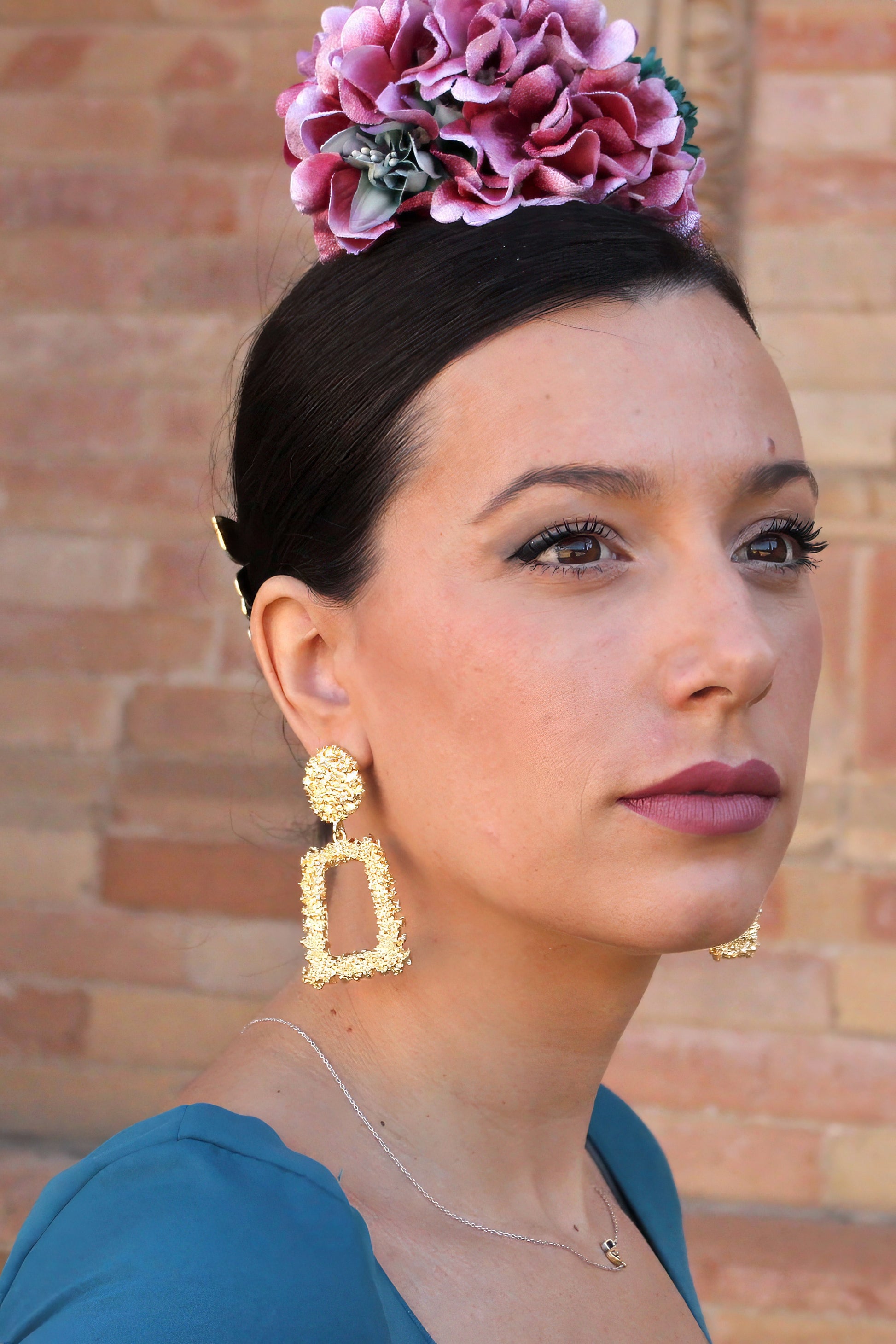 Con un diseño simple y elegante, los pendientes Carmona en dorado son el complemento perfecto para darle un toque de distinción a cualquier traje flamenco.