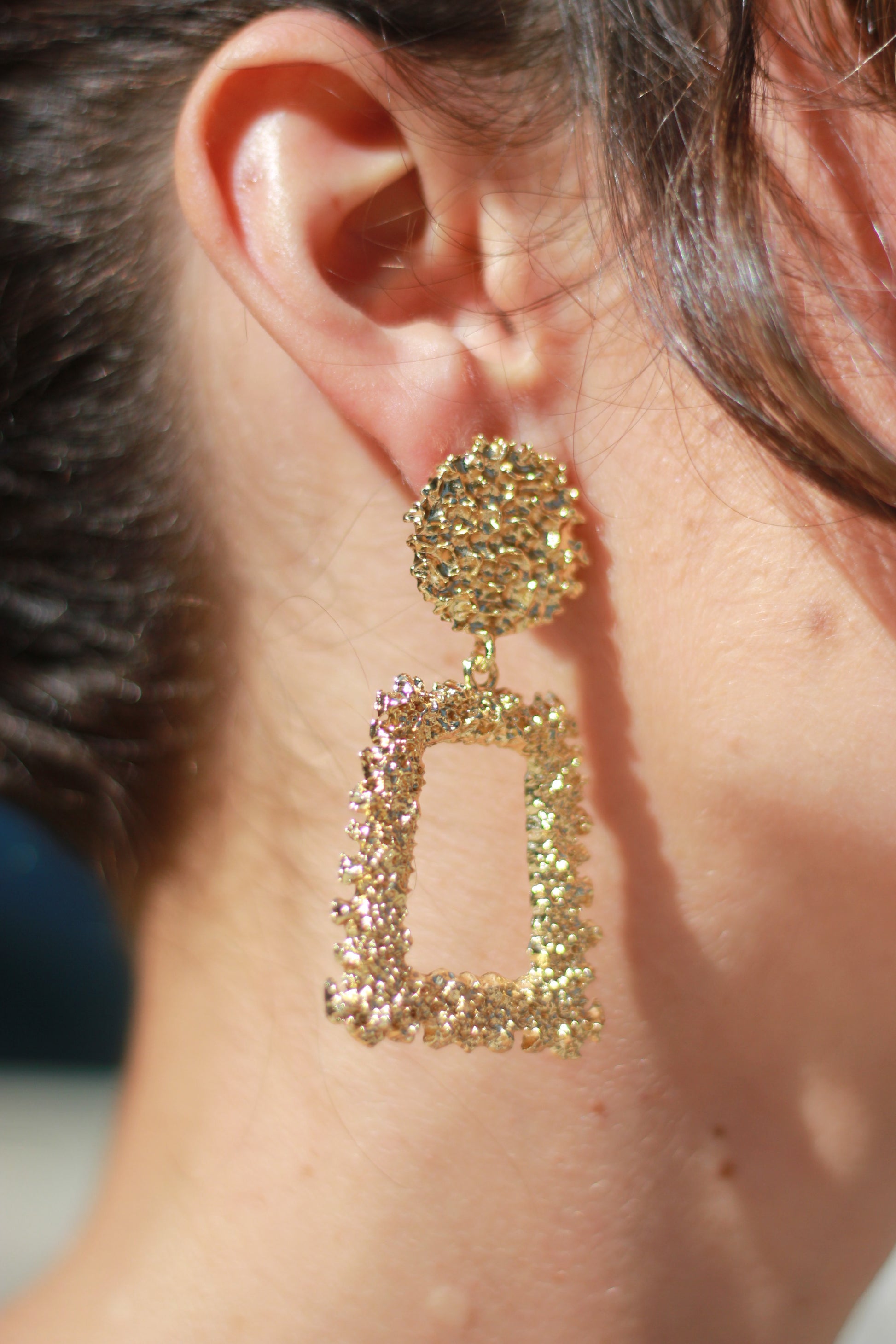 Los pendientes Carmona, con su diseño rectangular y elegante en dorado, añaden un toque sofisticado y sencillo a tu look flamenco.