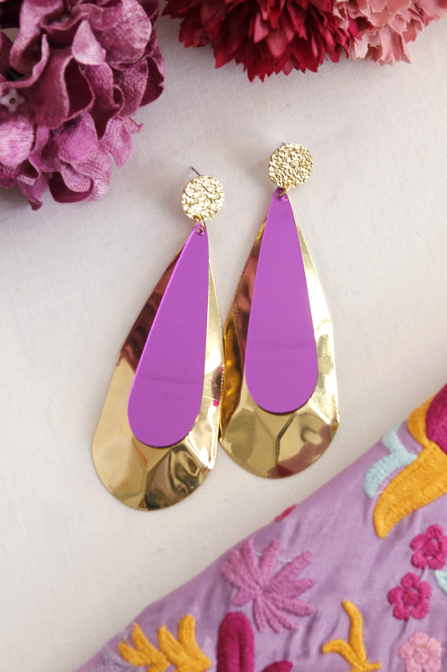 Los pendientes de flamenca Écija destacan por su diseño largo y elegante, combinando un acabado dorado con detalles en un delicado color morado. Su forma estilizada aporta un toque sofisticado y original, ideal para complementar cualquier traje de flamenca con estilo y distinción. Perfectos para quienes buscan un accesorio que resalte su look en ferias y romerías.