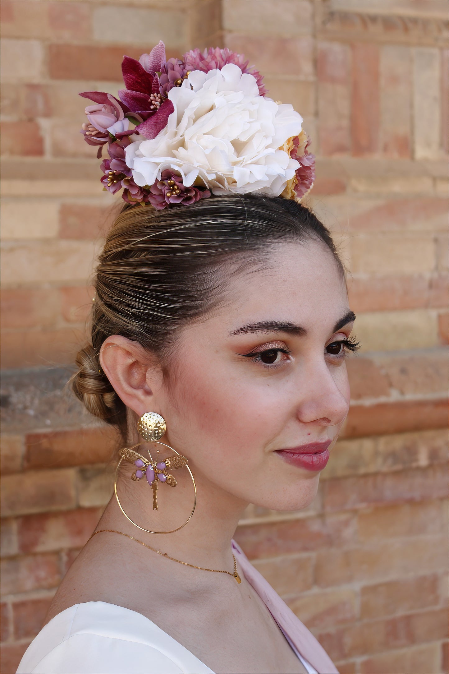 El ramillete Duende, hecho a mano en tonos blanco, rosa y amarillo, es el complemento perfecto para darle un toque encantador y suave a tu look flamenco. Su diseño elegante te hará destacar en cualquier evento flamenco.