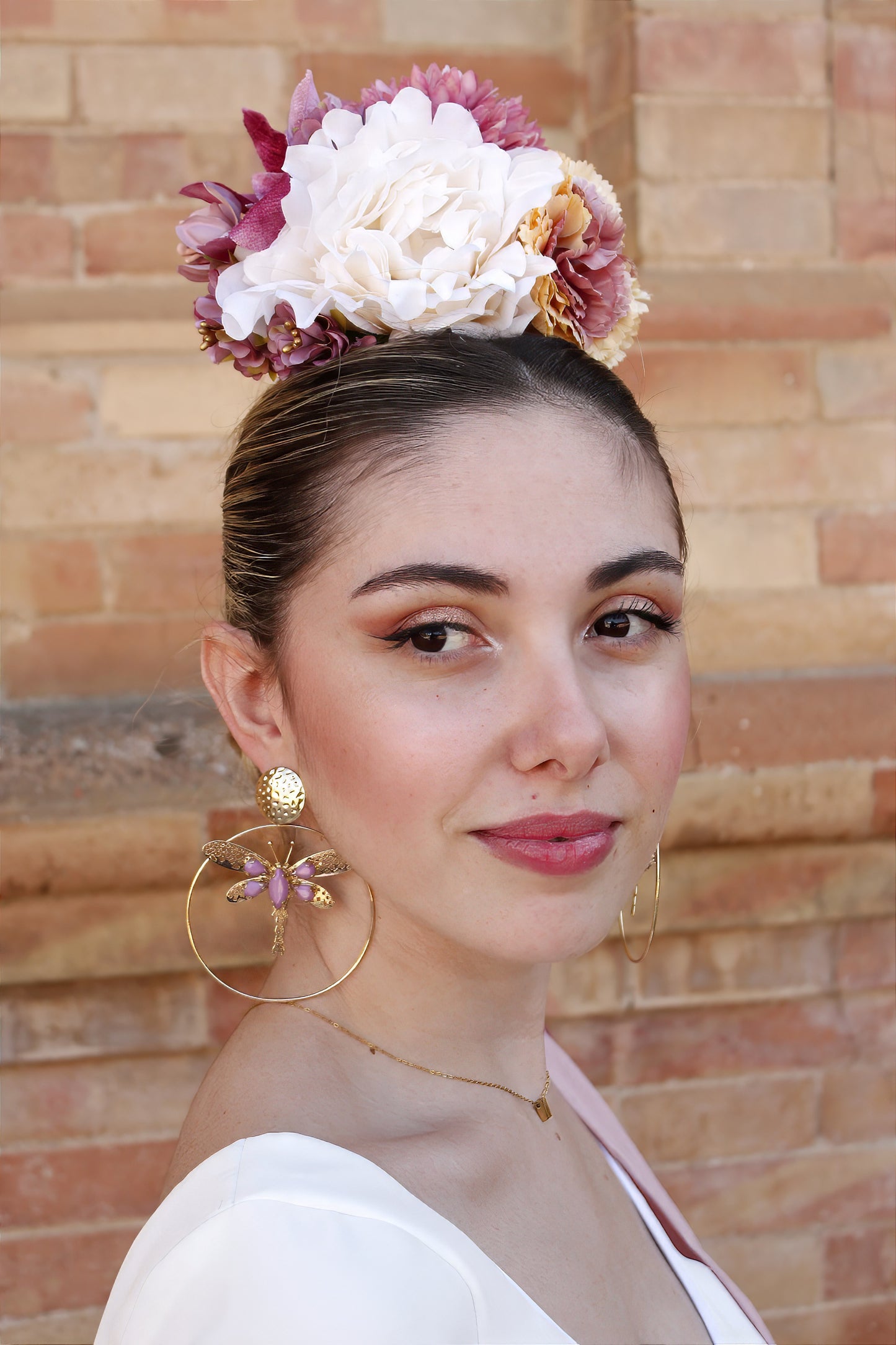 El ramillete Duende, hecho a mano en tonos blanco, rosa y amarillo, es el complemento perfecto para darle un toque encantador y suave a tu look flamenco. Su diseño elegante te hará destacar en cualquier evento flamenco.