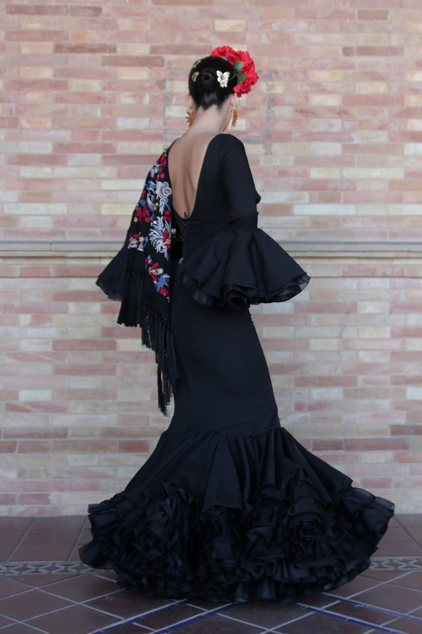 Traje de flamenca Clavel en negro, con volantes elegantes y corte sirena, ideal para lucir sofisticada en la Feria de Abril o romerías.