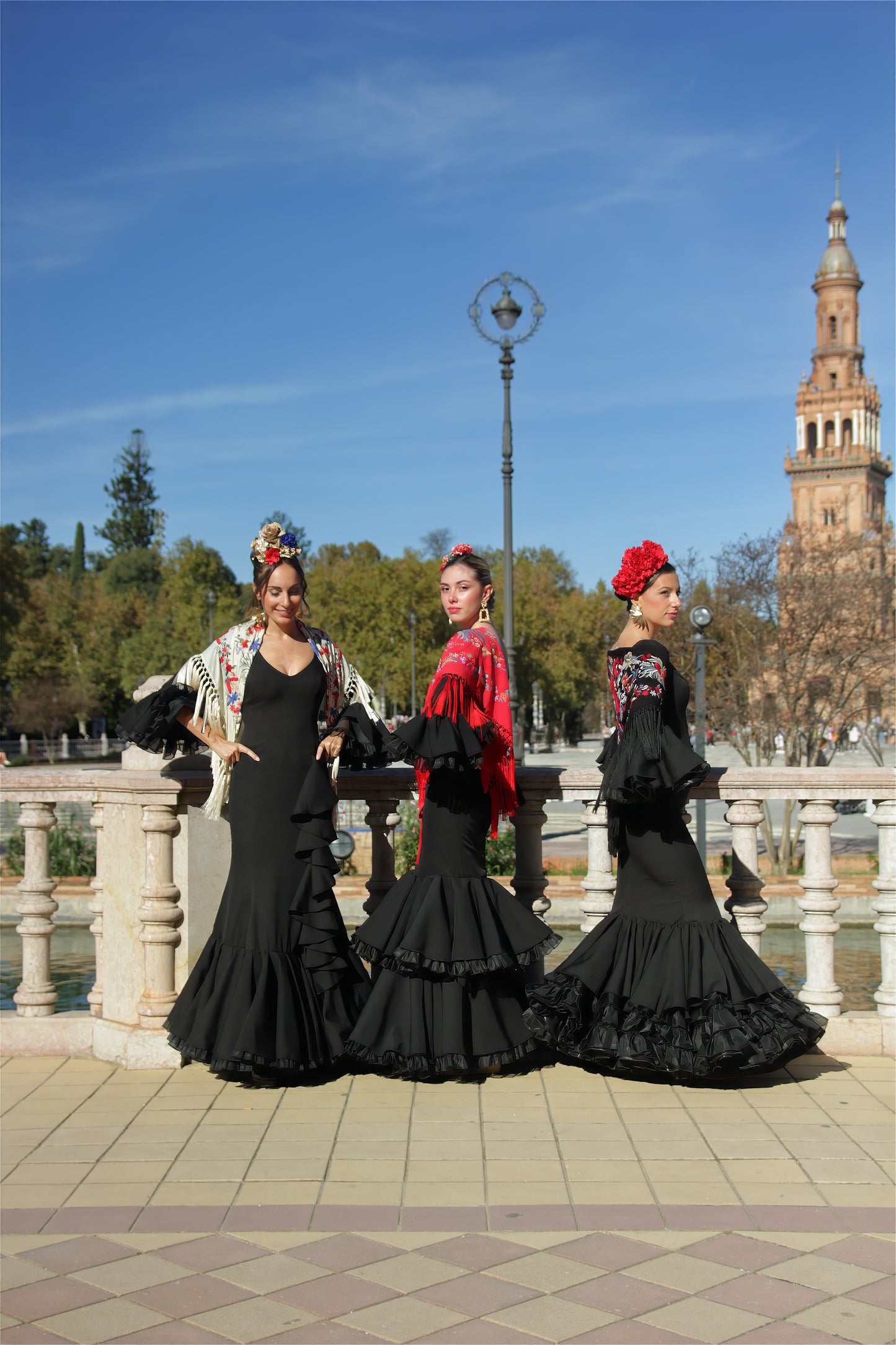 Tres trajes de flamenca Clavel en negro, diseñados con volantes elegantes, tejido de licra y corte sirena, ideales para la Feria de Abril y romerías.