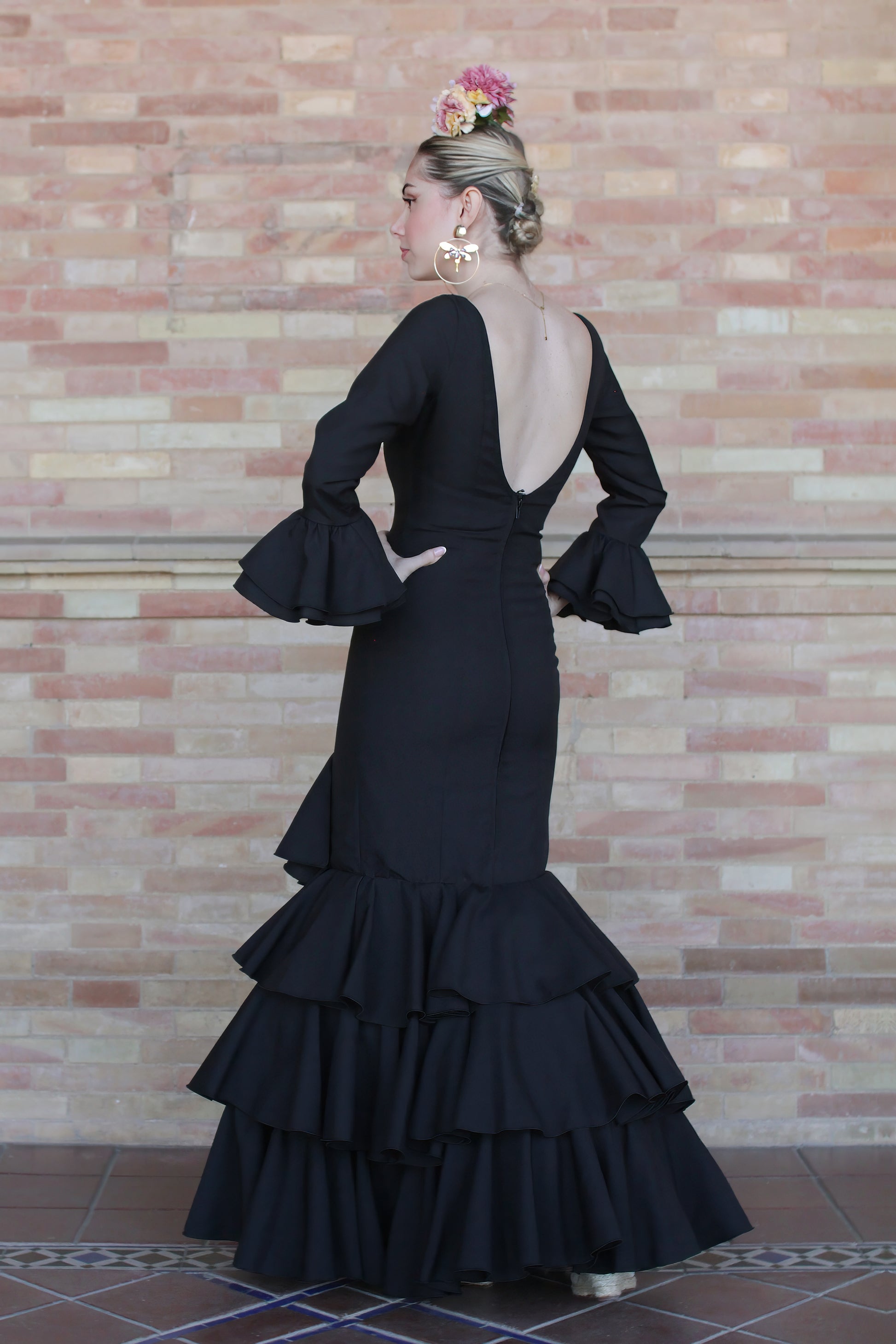 Traje de flamenca negro Dalia, pendientes de flamenca dorados y ramillete, perfecto para destacar con estilo.